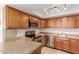Updated kitchen with wood cabinets, stone counters, and stainless appliances at 1051 S Dobson Rd # 137, Mesa, AZ 85202