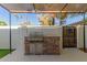 Outdoor kitchen with a built-in grill, stone facade, and convenient storage at 1051 S Dobson Rd # 137, Mesa, AZ 85202