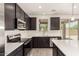 Modern kitchen with stainless steel appliances, white countertops, and dark cabinets at 11615 W Beck Ave, Youngtown, AZ 85363