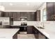 Close-up of kitchen with stainless steel appliances, white countertops, and modern dark cabinetry at 11615 W Beck Ave, Youngtown, AZ 85363