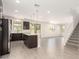 Spacious living room with tile flooring, staircase, and view into modern kitchen with stainless steel appliances at 11615 W Beck Ave, Youngtown, AZ 85363