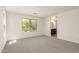 Bright living room featuring neutral carpeting and a large window offering abundant natural light at 11615 W Beck Ave, Youngtown, AZ 85363