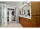 Bathroom featuring double vanity sinks, wood cabinets, a closet, and a tile floor at 11640 N Tatum Blvd # 3048, Phoenix, AZ 85028