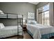 Comfortable bedroom with a bunk bed, a full sized bed and a large window at 11640 N Tatum Blvd # 3048, Phoenix, AZ 85028