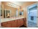 Bathroom featuring double sinks, a large mirror, and tile floor at 123 S Lucia Ln, Casa Grande, AZ 85194