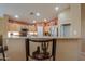 Bright kitchen with stainless steel appliances, warm wood cabinetry, and a breakfast bar at 123 S Lucia Ln, Casa Grande, AZ 85194
