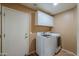 Functional laundry room with white cabinets, countertop space, and a full-size washer and dryer at 123 S Lucia Ln, Casa Grande, AZ 85194