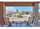 Relax and unwind on this covered patio featuring seating and a serene view of the beautiful backyard at 123 S Lucia Ln, Casa Grande, AZ 85194
