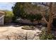 Lush backyard featuring a stone patio, circular flower bed, and mature landscaping at 1313 W Straford Ave, Gilbert, AZ 85233