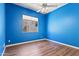 Bedroom with wood floors, ceiling fan, and a bright blue accent wall at 1313 W Straford Ave, Gilbert, AZ 85233