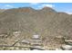 Aerial view showcasing tennis courts and luxury homes nestled in the mountains at 13662 E Shaw Butte Dr, Scottsdale, AZ 85259