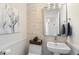 Stylish powder room features stone accent wall, pedestal sink and elegant fixtures at 13662 E Shaw Butte Dr, Scottsdale, AZ 85259