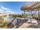 Inviting backyard with pool, pergola, outdoor furniture, travertine tile and desert landscaping at 15313 S 180Th Ave, Goodyear, AZ 85338