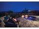 Outdoor oasis with a fire pit, relaxing lounge furniture, and a spa-like pool, perfect for evening relaxation at 15313 S 180Th Ave, Goodyear, AZ 85338