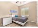 Bedroom featuring a ceiling fan, a window, tan walls, tile floor, and a gray bedspread at 15313 S 180Th Ave, Goodyear, AZ 85338