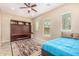 Bedroom with a Murphy bed, windows with blinds, and patterned rug on tile flooring at 15313 S 180Th Ave, Goodyear, AZ 85338