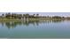 Scenic community lake view featuring fountains, palm trees, manicured lawns, and reflections on the water's surface at 15313 S 180Th Ave, Goodyear, AZ 85338