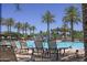 Community pool with lounge chairs, palm trees, a water slide, and umbrellas at 15313 S 180Th Ave, Goodyear, AZ 85338
