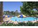 A zero entry community pool has a play structure and shade umbrellas at 15313 S 180Th Ave, Goodyear, AZ 85338