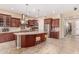 Bright kitchen with wooden cabinetry, a tiled backsplash, and a spacious center island with seating at 15313 S 180Th Ave, Goodyear, AZ 85338