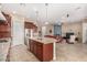 Open-concept kitchen with stainless appliances, an island with breakfast bar, and adjacent living room at 15313 S 180Th Ave, Goodyear, AZ 85338