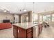 Granite topped island in an open concept kitchen and living area with stainless dishwasher and sink at 15313 S 180Th Ave, Goodyear, AZ 85338