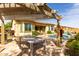 Covered patio with stylish table and outdoor kitchen overlooking the pool at 15313 S 180Th Ave, Goodyear, AZ 85338