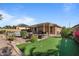 Spacious backyard featuring putting green, pool, covered patio, and desert landscaping at 15442 W Sells Dr, Goodyear, AZ 85395