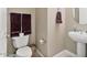 Practical half bathroom with a toilet, sink, and towel rack, designed for convenience at 15442 W Sells Dr, Goodyear, AZ 85395