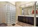 Bathroom features a tiled floor, a shower with glass block, and double sinks with cabinets at 15442 W Sells Dr, Goodyear, AZ 85395