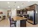 Bright kitchen with a large granite island, stainless steel refrigerator, and dark wood cabinetry at 15442 W Sells Dr, Goodyear, AZ 85395