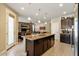 Lovely kitchen showcasing an island with granite counters, pendant lighting, and dark wood cabinets at 15442 W Sells Dr, Goodyear, AZ 85395