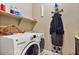 Convenient laundry room with a washer, dryer, storage shelf and ironing board at 15442 W Sells Dr, Goodyear, AZ 85395
