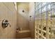 Tiled shower featuring glass block, neutral finishes, and a built-in seat at 15442 W Sells Dr, Goodyear, AZ 85395