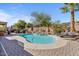 Backyard pool area with a waterfall feature, desert landscaping, and lounge chairs at 15442 W Sells Dr, Goodyear, AZ 85395