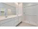 Bright bathroom featuring a double vanity with white cabinets and a spacious walk-in shower at 15564 W Williams St, Goodyear, AZ 85338