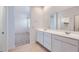 Bathroom featuring double vanity with white cabinets, framed mirror, and tile flooring at 15564 W Williams St, Goodyear, AZ 85338