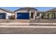 Charming single-story home featuring a stucco facade, blue garage door, and low-maintenance desert landscaping at 15564 W Williams St, Goodyear, AZ 85338