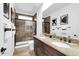A well-lit bathroom featuring a double sink vanity, granite counters and a tiled shower with glass doors at 15865 E Lost Hills Dr, Fountain Hills, AZ 85268