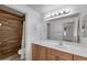 Bright bathroom features a wood vanity, neutral countertop, large mirror, and tiled shower at 19777 N 76Th St # 2150, Scottsdale, AZ 85255