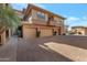 Exterior view of tan townhome featuring two car garage and lush landscaping at 19777 N 76Th St # 2150, Scottsdale, AZ 85255