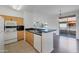 Open kitchen with matching wood cabinets and breakfast bar looking out to open floor plan and patio at 19777 N 76Th St # 2150, Scottsdale, AZ 85255