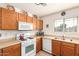 Bright kitchen features wood cabinets, white appliances, and ample counter space at 1994 E Dust Devil Dr, San Tan Valley, AZ 85143