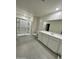 Bright bathroom with a tiled floor, glass-enclosed shower, white cabinets, and a large mirror at 2075 E Bucking Bronco Dr, San Tan Valley, AZ 85140