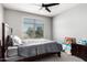 Bright bedroom with a ceiling fan, a window with green view, and a bed with gray bedding at 25318 N 19Th Dr, Phoenix, AZ 85085