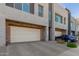 Modern townhome featuring a two-car garage with paved driveway and desert landscaping at 25318 N 19Th Dr, Phoenix, AZ 85085