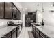 Stylish kitchen with a granite island, stainless steel appliances, and dark cabinetry at 25318 N 19Th Dr, Phoenix, AZ 85085