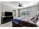 Comfortable main bedroom featuring a ceiling fan, dresser with TV, and a view to the en suite bathroom at 25318 N 19Th Dr, Phoenix, AZ 85085