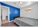 This bedroom features a grey comforter and a bright blue accent wall at 2940 W Townley Ave, Phoenix, AZ 85051