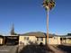 Charming single-story home with a well-maintained yard and a towering palm tree against a bright blue sky at 2940 W Townley Ave, Phoenix, AZ 85051